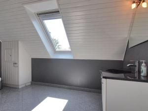 een badkamer op zolder met een wastafel en een raam bij Holiday Home Spase - 250m to the fjord by Interhome in Nakskov