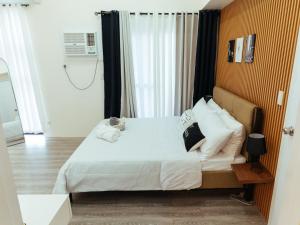 ein Schlafzimmer mit einem Bett mit weißen Laken und Kissen in der Unterkunft Hannah's Place in Davao City