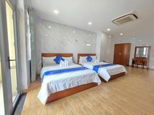 a bedroom with two beds with blue pillows at DŨNG India HOTEL in Ho Chi Minh City