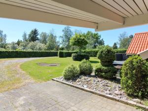 a backyard with a patio and a garden with bushes at Holiday Home Gretta - 400m from the sea by Interhome in Dannemare