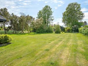 an empty field with trees and a house at Holiday Home Veljan - 400m from the sea by Interhome in Bogense