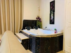 y baño con bañera y suelo de baldosa negra. en Labelva court Mosi oa tunya, en Lusaka 4 fotos más