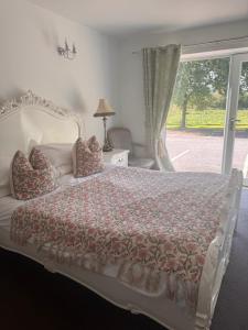 a bedroom with a large bed with a window at The Old Stone Trough Country Hotel in Kelbrook