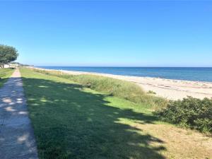 una acera junto a una playa con el océano en Holiday Home Ulv - 25m from the sea by Interhome, en Otterup