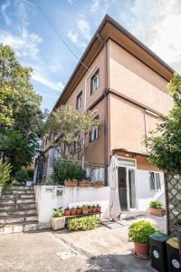 a building with a porch and stairs and plants at Hotel Locanda Gaia in Muggia