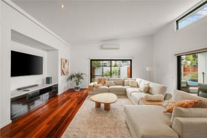 ein Wohnzimmer mit Sofa und Fernseher in der Unterkunft Malabar Retreat by Ready Set Stay in Cowes