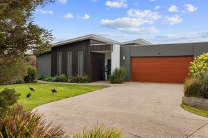 ein Haus mit einer roten Garagentür in der Unterkunft Malabar Retreat by Ready Set Stay in Cowes