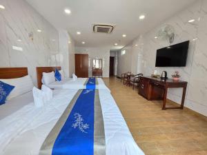 a large room with a large bed and a flat screen tv at DŨNG India HOTEL in Ho Chi Minh City