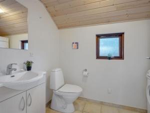 ein Badezimmer mit Toilette und Waschbecken und einem Fenster in der Unterkunft Holiday Home Matine - 800m from the sea by Interhome in Rødby