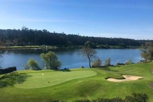 a golf course with a lake in the background at Varandas do Pinhal in Fão