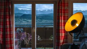 een kamer met een raam met uitzicht op de bergen bij Wygodno in Szlembark