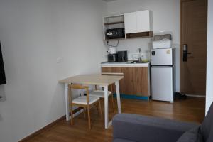 Ban Pra DokにあるCondo Caesar's Suite Koratのテーブルと冷蔵庫のある小さなキッチン +13枚の写真