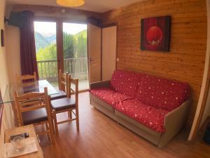 a living room with a red couch and a table at Orelle 3 Vallées - 2 pièces 3 personnes in Orelle