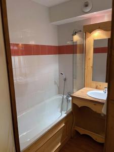a bathroom with a bath tub and a sink at Orelle 3 Vallées - 2 pièces 3 personnes in Orelle