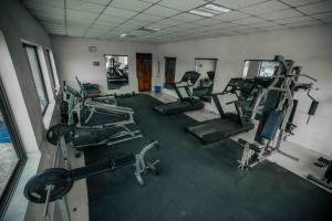 a gym with several tread machines in a room at Mbeya Forest Hill Motel in Mbeya