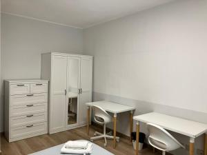 a white room with a desk and a dresser at Grattacielo Rooms in Turin +17 photos