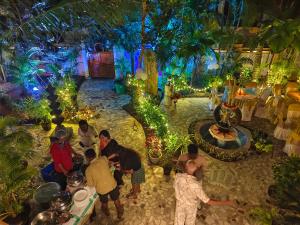 a group of people standing in a garden with lights at Maharaju Palace in Kovalam