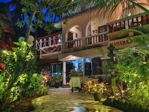 a house with a table in the garden at night at Maharaju Palace in Kovalam