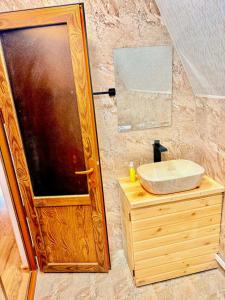 a bathroom with a wooden door and a sink at La Seasons in Hors +23 photos