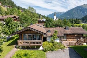 ein Haus in einem Bergdorf mit einer Kirche in der Unterkunft Schöneben Chalet Schneerose in Wald im Pinzgau