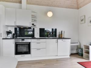 Una cocina con gabinetes blancos y un horno de estufa. en Holiday Home Wrage - 500m from the sea by Interhome, en Ny Vemmenæs 20 fotos más