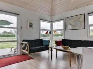 una sala de estar con un sofá y una mesa en Holiday Home Wrage - 500m from the sea by Interhome, en Ny Vemmenæs