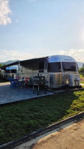 Una casa rodante plateada estacionada en un campo con una mesa de picnic. en Bieszczadzki Airstream, en Wetlina