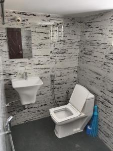 Un baño con un inodoro blanco y un lavabo. en Papillon Paradise, en Gonikoppal