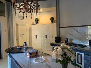 una cocina con un jarrón de flores en un mostrador en Labelva court Mosi oa tunya, en Lusaka