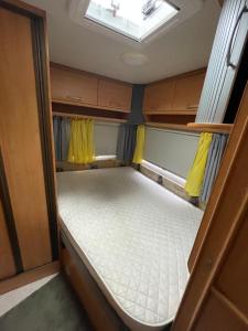 un piccolo letto sul retro di un camper di Südwind Wohnwagen a Maintal