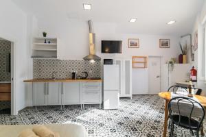 a kitchen with white appliances and a table and chairs at INT Studio totalmente equipado, 15' de BCN centro 8' playa in Sant Adria de Besos