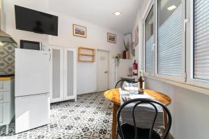 a kitchen with a table and chairs and a tv at INT Studio totalmente equipado, 15' de BCN centro 8' playa in Sant Adria de Besos +4 photos