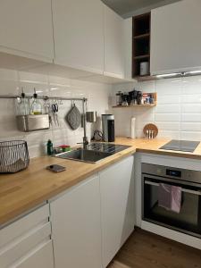 a kitchen with white cabinets and a sink at MySchluchseehome Gemütliche Ferienwohnung mit Südbalkon und Pool im Haus in Schluchsee