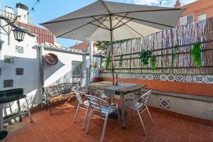 a table and chairs with an umbrella on a patio at Barcelona Studios with private kitchen, toilet & shower 20min from the center 5min to the beach in Sant Adria de Besos