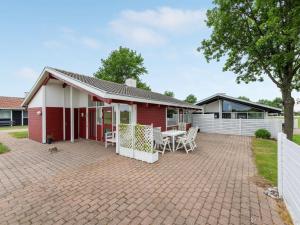 a red house with a table and chairs on a patio at Apartment Ditte - 300m from the sea by Interhome in Aabenraa