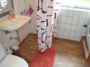 a bathroom with a toilet and a sink and a shower curtain at Holiday Home Claudia by Interhome in Bredebro +10 photos