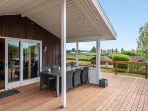 a patio with a table and chairs on a wooden deck at Holiday Home Ellyn - 500m from the sea by Interhome in Haderslev