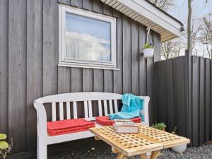 a white bench sitting next to a fence with a table at Holiday Home Gunholm - 150m from the sea by Interhome in Haderslev
