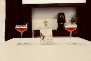 una bottiglia di vino e due bicchieri su un tavolo di Elene Suites Boutique a Palermo Altre 18 foto