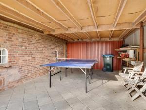 a ping pong table in a room with a brick wall at Holiday Home Hedda - 15km from the sea by Interhome in Ballum
