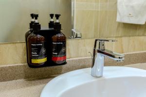 two bottles ofodorizers sitting on a counter next to a sink at Infinity Plaza Hotel Block 2 in Atyrau +43 photos