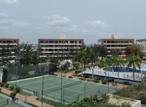 a tennis court in front of some buildings at Condominio Nobless Angola Talatona in Luanda