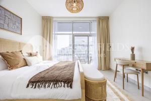a bedroom with a bed and a desk and a window at Bloomfields Spacious 2br in Lamar Raha in Abu Dhabi