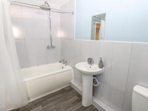 a white bathroom with a sink and a bath tub at Georgian Town House in Whitehaven +26 photos