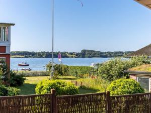 a view of the water from a house with a fence at Holiday Home Star - 100m from the sea by Interhome in Rødekro