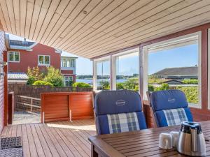 a porch with two blue chairs and a wooden table at Holiday Home Star - 100m from the sea by Interhome in Rødekro