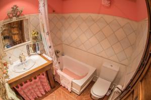 a bathroom with a sink and a tub and a toilet at Villa Rural "La casa de ANA" in Muelas de los Caballeros +49 photos