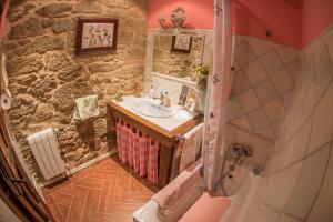 a bathroom with a sink and a stone wall at Villa Rural "La casa de ANA" in Muelas de los Caballeros