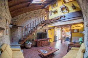 a living room with a staircase and a television at Villa Rural "La casa de ANA" in Muelas de los Caballeros
