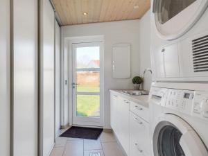 a white laundry room with a washer and dryer at Holiday Home Fengur - 330m from the sea by Interhome in Humble +18 photos